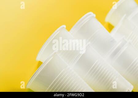 Plastic tableware on a yellow background with free space. Disposable tableware Stock Photo
