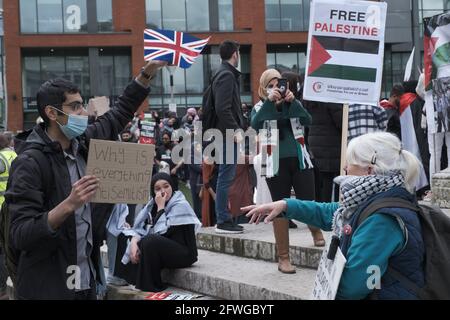 Lady argues with a protestor waving Union Jack as Protestors gather at Piccadilly Gardens, Manchester UK. The Demonstration started at 12 pm 22 May 2021. The protest was to show support for the Palestianian people and against the recent escalation of conflict in the region. In Palestine the Palestinian people have faced a contat barrage from Israel following rockets fired from Gaza by th ruling Hamas militant group. The ceasefire began early on Friday 20th May 2021,  bringing to an end 11 days of fighting in wich more than 250 people were killed, most of them in Gaza. Picture: ALVAROVELAZQUEZ/ Stock Photo