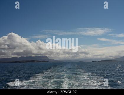 View from ferry to Outer Hebrides from The Minch sea with ferry water wake, distant views of mountains of Assynt and mainland Scotland. Sunny day. Stock Photo