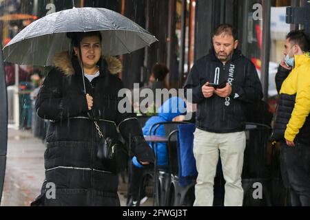 London, UK. 17th May, 2021. A woman shelters from rain beneath an umbrella just before a torrential downpour in London. (Photo by Dinendra Haria/SOPA Images/Sipa USA) Credit: Sipa USA/Alamy Live News Stock Photo