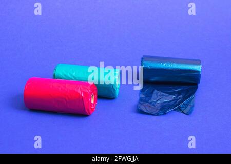 Multicolored rolls of plastic bags on blue background close up Stock Photo