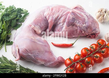 Raw and fresh meat. Whole rabbit ready to cook with ingredients set, on white stone background Stock Photo