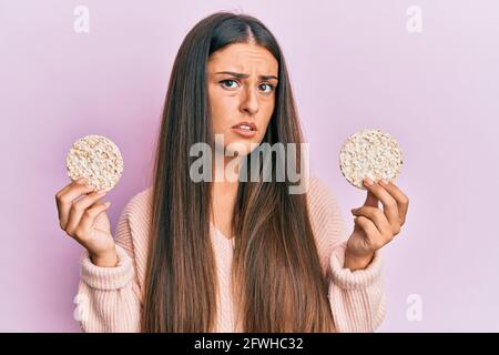 Emotional young woman eating rice at home Stock Photo - Alamy