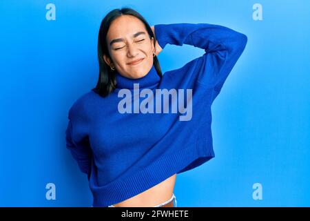 Young asian woman wearing casual winter sweater stretching back, tired and relaxed, sleepy and yawning for early morning Stock Photo
