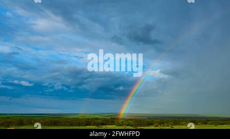 The Rainbow over Rural Landscape after Thunderstorm. Stock Photo