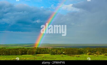 The Rainbow over Rural Landscape after Thunderstorm. Stock Photo