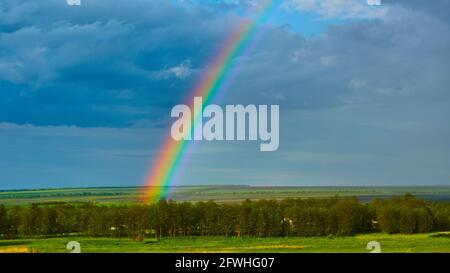 The Rainbow over Rural Landscape after Thunderstorm. Stock Photo