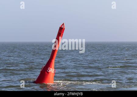 Red spar buoy swims in the North Sea Stock Photo