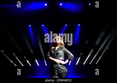 pretty woman artist over the background of blurred spotlights on the stage Stock Photo