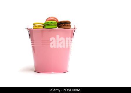 Macarons multicolored in a pink bucket on a white background Stock Photo