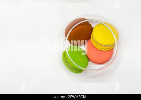 multicolored french macarons in a glass vase on a white background, top view Stock Photo