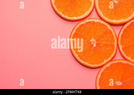 Sliced ripe oranges on a bright pink background. Stock Photo