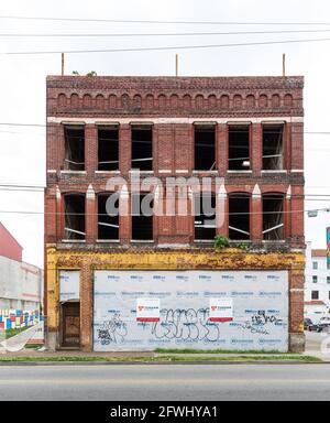 CHATTANOOGA, TN, USA-9 MAY 2021: Front view of gutted brick 3 story commercial building showing signs of renovation. Stock Photo