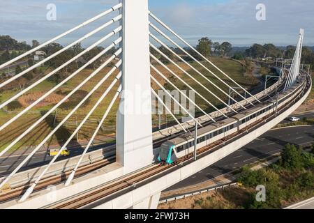 A Sydney Metro train traversing a bridge over Windsor Rd, Rouse Hill, NSW, Australia. Stock Photo