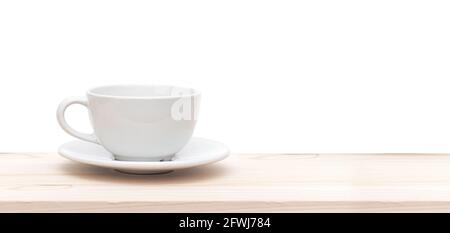 White ceramic cup or mug on wooden table in front of white background, space for text Stock Photo