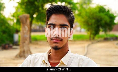 Close up face of fashionable Indian young boy on green background. Stock Photo