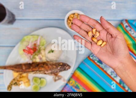 Woman holding a Peruvian corn nut known also as cancha, small appetizer plate . Selective Focus Stock Photo
