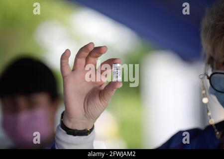 Bucharest, Romania - May 22, 2021: Details with the hand of a medical worker holding a dose of the Pfizer BioNTech Comirnaty anti Covid 19 vaccine at Stock Photo