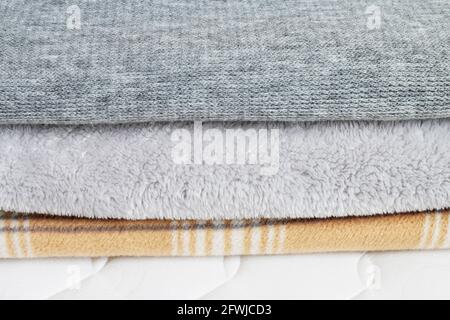Three blankets: grey and beige on the mattress. Graphic resources Stock Photo