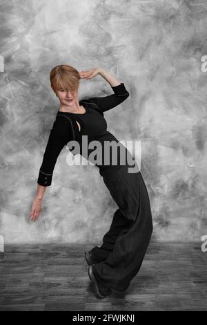 A woman in black clothes does a contemporary hip hop dance Stock Photo
