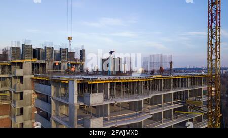 Workers on a high-rise building in the evening clog the formwork for pouring concrete. Stock Photo