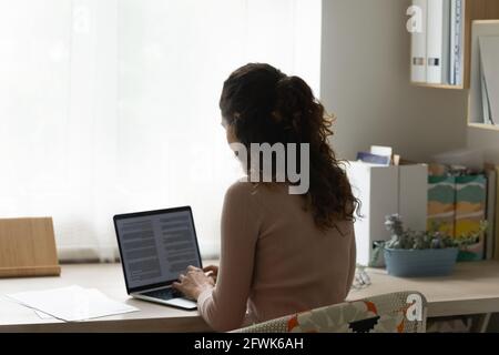 Young woman working on computer at home office. Stock Photo