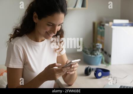 Happy millennial hispanic woman using mobile software application. Stock Photo