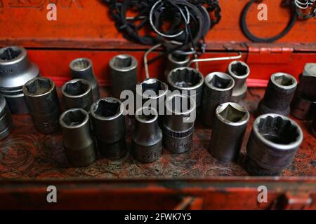 Kuwait City – Kuwait – April 15, 2021: Used a dirty wrench adapters against red metal background Stock Photo