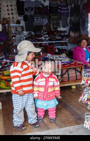 Cute local Quechua children in a shop in Chinchero, a small Andean rustic village in the Sacred Valley, Urubamba Province, Cusco Region, Peru Stock Photo