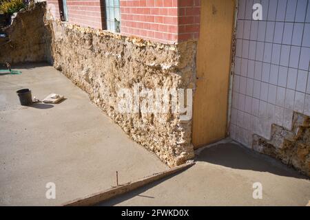 Construction of foundations next to the wall of the existing cottage Stock Photo