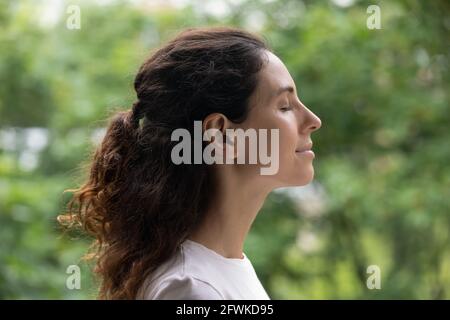 Peaceful happy young woman meditating with closed eyes. Stock Photo