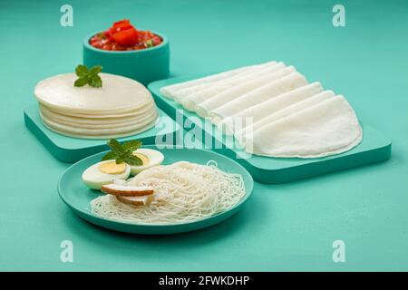 Rice Pathiri and Ideyappam, south indian malabar special breakfast made using rice flour which is white in colour, arranged in a aquamarine solid colo Stock Photo