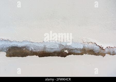 White color painted old peeling cracked plaster wall background Stock Photo