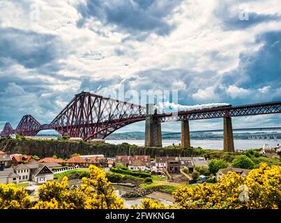Flying Scotsman steam train crossing the iconic Forth Rail Bridge on its way towards Fife seen from North Queensferry, Scotland, UK Stock Photo