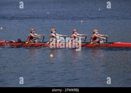 Young women's coxed quad rowing in unison at regatta. Lake Natoma, CA Stock Photo