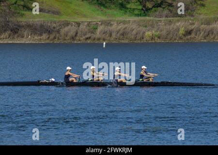 Young women's coxed four rowing in unison during regatta at Lake Natoma, California Stock Photo