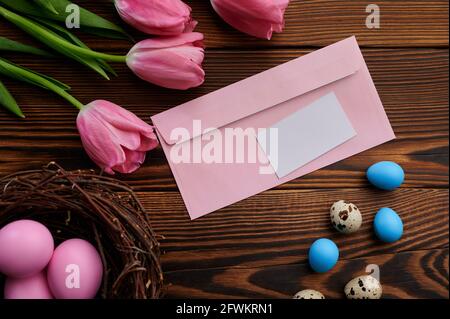 Pink tulips, easter eggs and greeting envelope Stock Photo