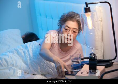 Old people sitting on the bed to see a mobile phone Stock Photo