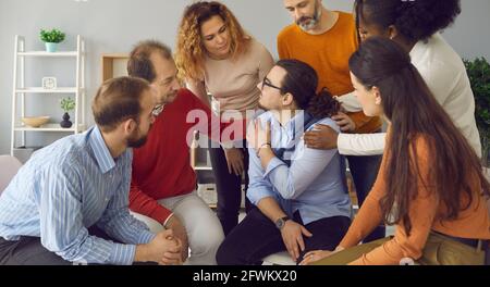 Diverse multiethnic people psychological giving support embracing teammate Stock Photo