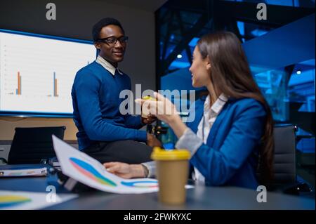 Two managers talks at the table in night office Stock Photo