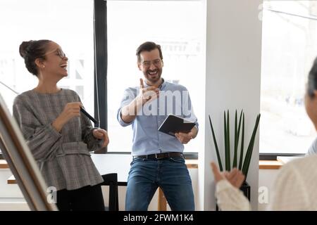 Overjoyed diverse colleagues having fun at meeting, laughing at joke Stock Photo