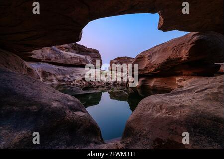 Geological hole cave in large rocky rapids and pond reflection in the evening at Sam Phan Bok, Ubon Ratchathani Stock Photo