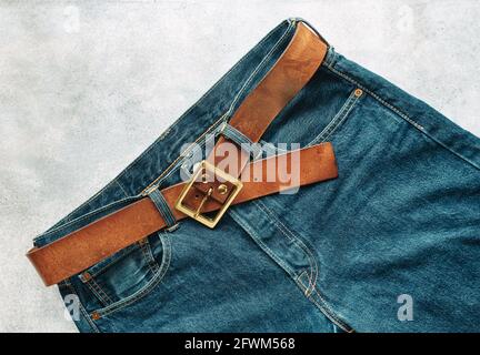 Blue mens denim pants, jeans, with a leather belt, fashion clothing concept. View from above with copy space Stock Photo