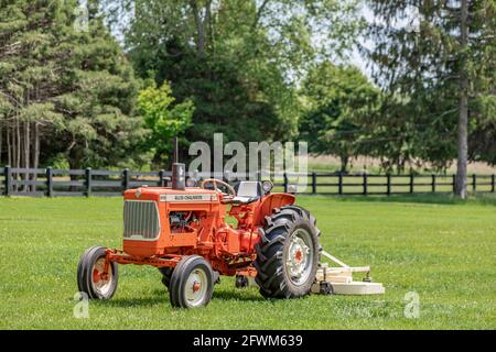 An ornage Allis Chalmers farm tractor sitting in a green field Stock Photo