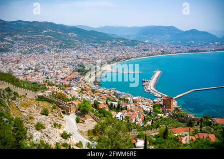 Beautiful views of the city of Alanya from above. An ancient defensive wall buried in green trees and a resort town surrounded by a blue sea on one si Stock Photo