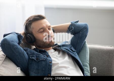 Joyful middle-aged man in headphones listening to music Stock Photo