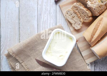 butter in container and whole meal bred on table  Stock Photo