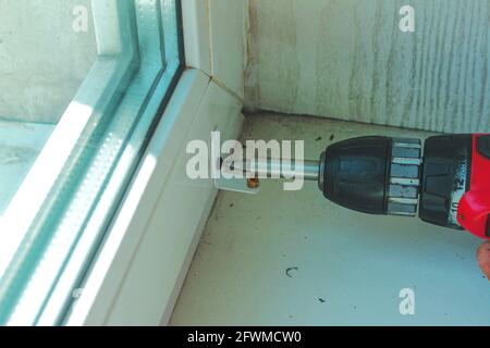 Window blinds installation process. Working with a drill. Stock Photo