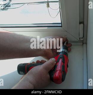 Window blinds installation process. Male hands close up. Stock Photo