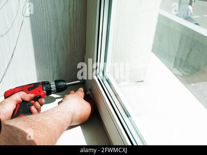 Window blinds installation process. Male hands close up. Stock Photo